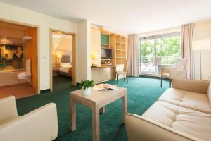 a living room with a couch and a table at Suite Hotel Leipzig in Leipzig