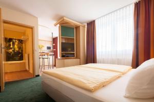 a bedroom with a bed and a large window at Suite Hotel Leipzig in Leipzig