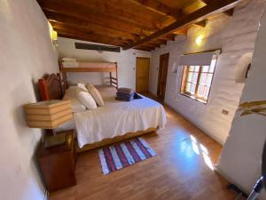 1 dormitorio con 1 cama y suelo de madera en Atacama Lodge Rukazen Spa Rústico, en San Pedro de Atacama