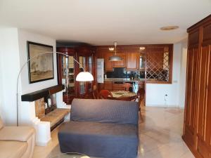 Nogalera Sea&Sun Apartment في توريمولينوس: غرفة معيشة مع أريكة ومطبخ