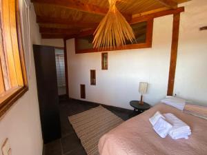1 dormitorio con 1 cama en una habitación con ventana en Atacama Lodge Rukazen Spa Rústico, en San Pedro de Atacama