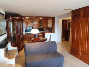 Nogalera Sea&Sun Apartment في توريمولينوس: غرفة معيشة مع أريكة زرقاء وطاولة