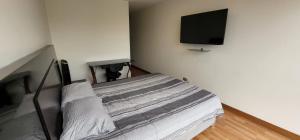 una camera con letto e TV a schermo piatto di Grimaldo del Solar 219 Miraflores OMM1 a Lima