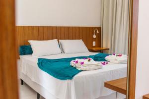 a bedroom with a bed with two towels on it at Caly Pousada in São Miguel do Gostoso +60 photos