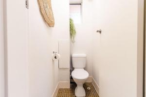 a bathroom with a white toilet in a stall at Thurlow Lodge, 7,6 Thurlow Avenue - Beautifully styled unit with WiFi, views and a pool in Nelson Bay +18 photos