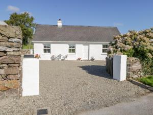 a white house with a gravel driveway at Tigh Mhicheal Phaidin in Finny