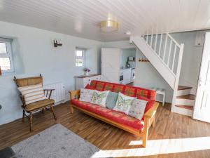 sala de estar con sofá rojo y escalera en Tigh Mhicheal Phaidin en Finny