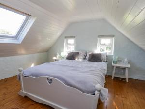 1 dormitorio con 1 cama blanca en el ático en Tigh Mhicheal Phaidin en Finny