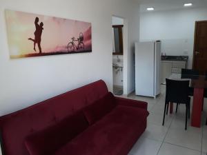a living room with a red couch and a painting on the wall at Aconchego Serra Imperial -102 in Petrópolis