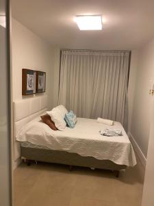 a small bed in a bedroom with a window at Praia do Forte Iberostar in Praia do Forte