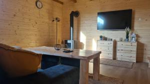 a wooden room with a wooden table and a tv at Ostoja Ldzań 