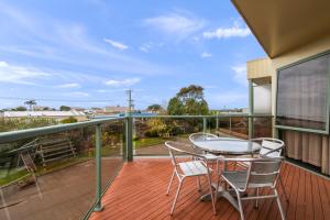a patio with a table and chairs on a balcony at Comfort Inn & Suites Lakes Entrance in Lakes Entrance