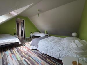 sypialnia z 2 białymi łóżkami i zielonymi ścianami w obiekcie Maison familiale, plage à pied, proche St MALO w mieście Saint-Coulomb