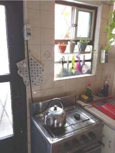 uma chaleira de chá numa placa de fogão na cozinha em Cálido apartamento a 8 cuadras del mar y a 3 de 18 Julio Hay una gatita que vive allí em Montevidéu