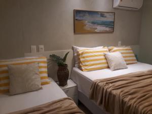two beds sitting next to each other in a bedroom at Flat em Porto de Galinhas com Piscina Exclusiva in Porto De Galinhas +35 photos