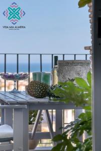 a table with fruit on a balcony with the ocean in the background at Vida Mia Almeria - Superior Apartment in Vera