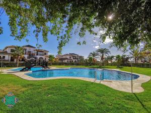 a swimming pool in a yard with houses in the background at Vida Mia Almeria - Superior Apartment in Vera