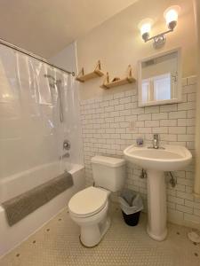 a white bathroom with a toilet and a sink at Furnished Apartments - Climate Pledge Arena Next Door in Seattle