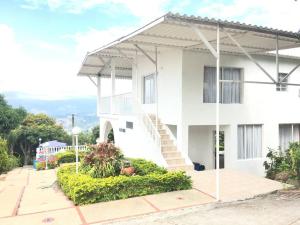 una casa blanca con una escalera delante en Casa de campo mesitas del colegio, en El Colegio