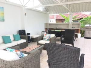 eine Terrasse mit Korbmöbeln und einem Klavier in der Unterkunft Casa de campo mesitas del colegio in El Colegio