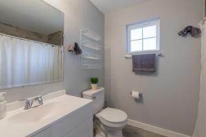 Un baño con inodoro, lavabo y ventana. en Eastlawn Place cozy 2 bdrm townhome near downtown San Antonio, en San Antonio 25 fotos más