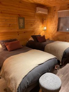 a bedroom with two beds in a log cabin at Hotel Palafito Entre Mar y Tierra in Castro