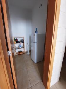 a kitchen with a white refrigerator in a room at Blue Sardine Hostel in Portimão