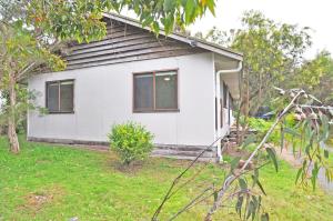 a white house with windows in a yard at GUMNUT COTTAGE - FREE WIFI & FOXTEL in Inverloch