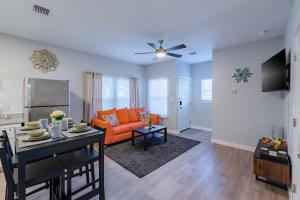 uma sala de estar com um sofá laranja e uma mesa em Eastlawn Place cozy 2 bdrm townhome near downtown San Antonio em San Antonio