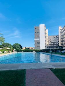 a large swimming pool with buildings in the background at Charming & cosy beach apartment in Torremolinos