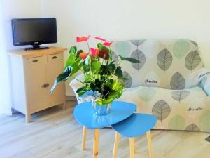 uma sala de estar com uma mesa com um vaso de flores em Gîte Saint-Georges-du-Bois, 2 pièces, 2 personnes - FR-1-410-336 em Rouillon