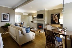 uma sala de estar com um sofá, uma mesa e uma lareira em Verandah House Country Estate em Mount Tamborine