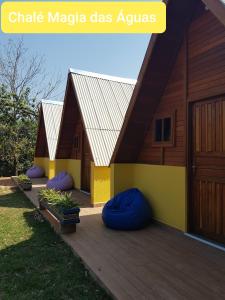 una casa con una terrazza in legno con sacchetti di fagioli viola di Chalés Magia das Águas ad Águas de Lindóia