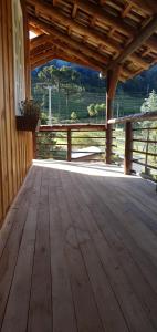 a large wooden deck with a view of a field at Casarão Biazolli in Farroupilha