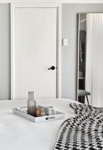 a white bedroom with a bed with a tray on it at No 9 Springfield in Sydney