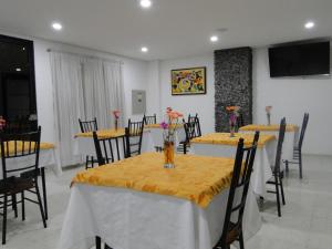 Hotel Esmeralda Plaza في زيباكويرا: غرفة طعام مع طاولات وكراسي مع طاولة قماش صفراء