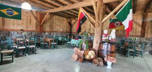 a large room with tables and chairs and flags at Casarão Biazolli in Farroupilha