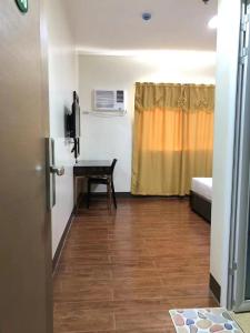 a room with a desk and a bed and a window at Meaco Royal Hotel- Aparri in Camalaniugan