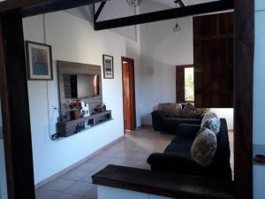 uma sala de estar com dois sofás e uma televisão em Sítio Vista da Serra em Lavrinhas