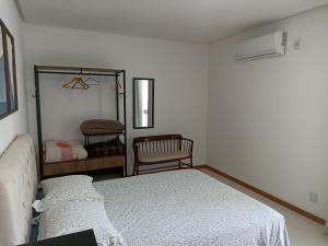 a white bedroom with a bed and a mirror at Flat Santa Cruz II in Santa Cruz do Sul