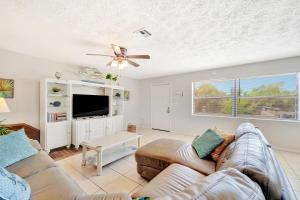 een woonkamer met een bank en een flatscreen-tv bij Blissful Beach Retreat A in Englewood