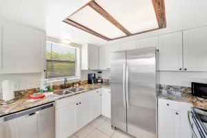 een keuken met witte kasten en een roestvrijstalen koelkast bij Blissful Beach Retreat A in Englewood +22 foto's