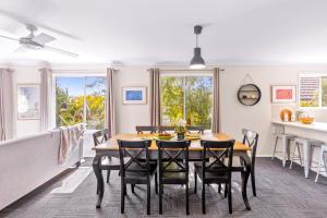 a kitchen and dining room with a table and chairs at Spring Cottage in Nowra