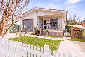 una staccionata bianca di fronte a una casa di Spring Cottage a Nowra