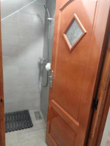 a wooden door in a bathroom with a shower at Harmony in Azrou