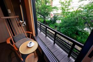 a balcony with a chair and a table and a window at Rinn Shijo Takase River North in Kyoto