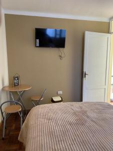 a bedroom with a bed and a tv on the wall at La Negrita Host in Sucre