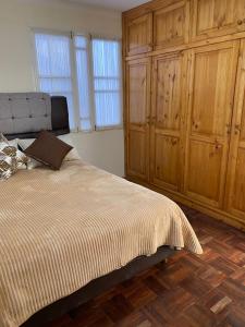 a bedroom with a bed and wooden cabinets at La Negrita Host in Sucre