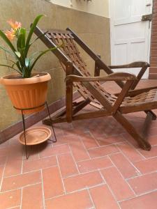 un fauteuil à bascule et une plante en pot sur une terrasse couverte dans l'établissement La Negrita Host, à Sucre