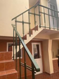 una rampa di scale in una casa con ringhiera verde di La Negrita Host a Sucre
